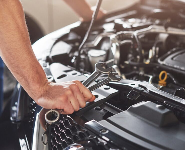 muscular-car-service-worker-repairing-vehicle